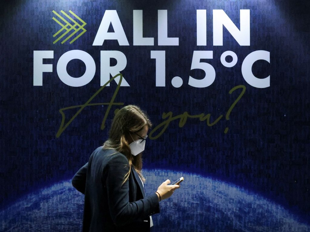 Una delegada pasa junto a un letrero durante la COP26 en Glasgow. (YVES HERMAN / REUTERS)