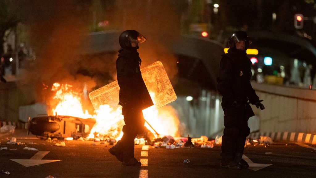 Dos policías frente a una barricada de los manifestantes concentrados en la sede del PSOE en la calle Ferraz de Madrid.