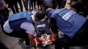 Colegas del periodista Salem Abu Tayour lo llevan en medio del patio del Hospital de los Mártires de Al-Aqsa en Deir al-Balah en Gaza