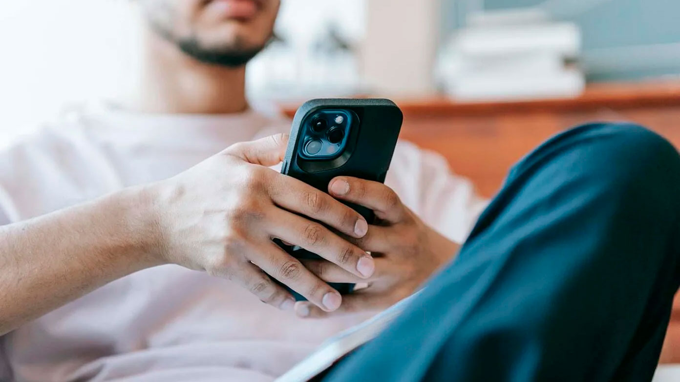 Una persona lee en su teléfono móvil.