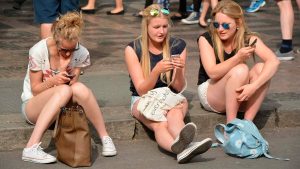 Tres mujeres consumen contenidos a través de un teléfono móvil