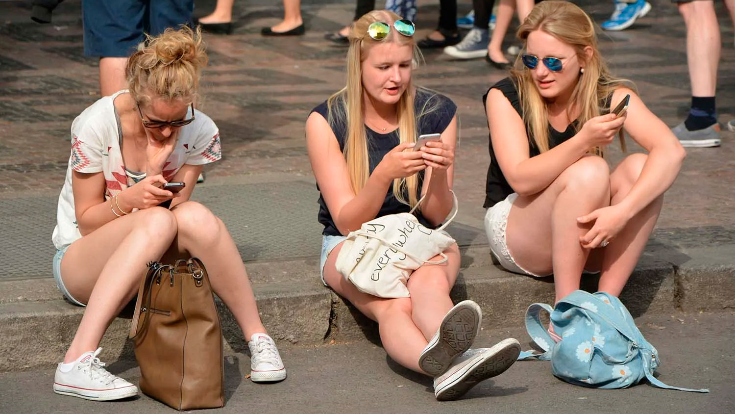 Tres mujeres consumen contenidos a través de un teléfono móvil